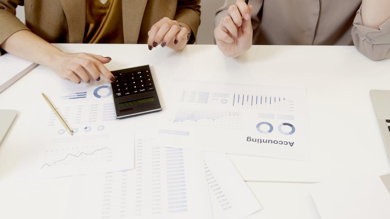about-01 Two professionals analyzing financial documents with a calculator.