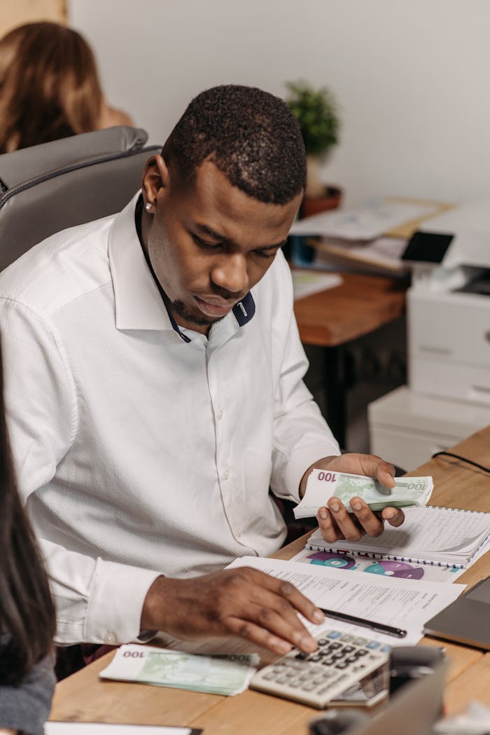gallery-6 Professional counting money in an office, emphasizing finance and accounting.